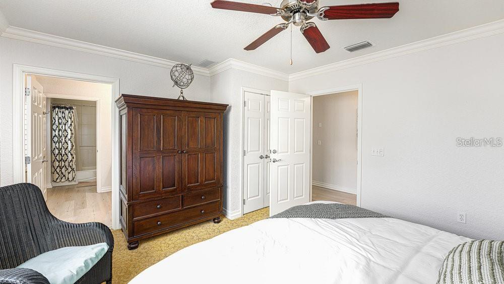 7650 Whisper Way, Unit 304 Reunion, FL 34747 - Photo 13 of 37 a bedroom with a bed and a mirror on the dresser