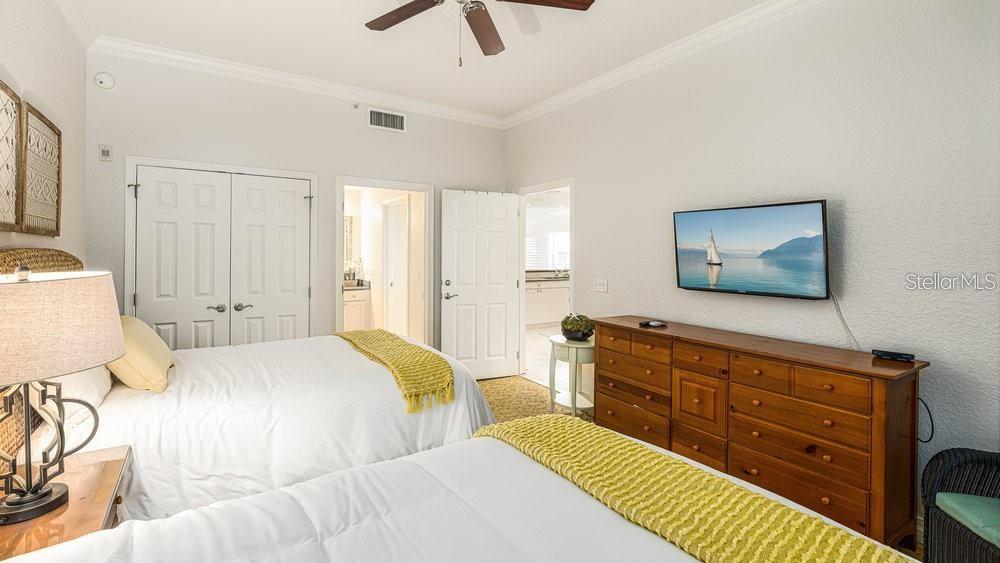 7650 Whisper Way, Unit 304 Reunion, FL 34747 - Photo 17 of 37 a bedroom with a bed a dresser and next to a window