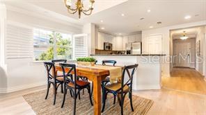 7650 Whisper Way, Unit 304 Reunion, FL 34747 - Photo 4 of 37 a dining area with stainless steel appliances kitchen island granite countertop a table and chairs