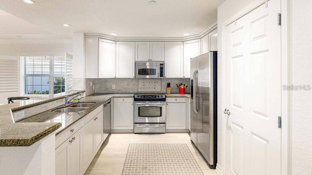 7650 Whisper Way, Unit 304 Reunion, FL 34747 - Photo 5 of 37 a kitchen with a refrigerator stove and sink