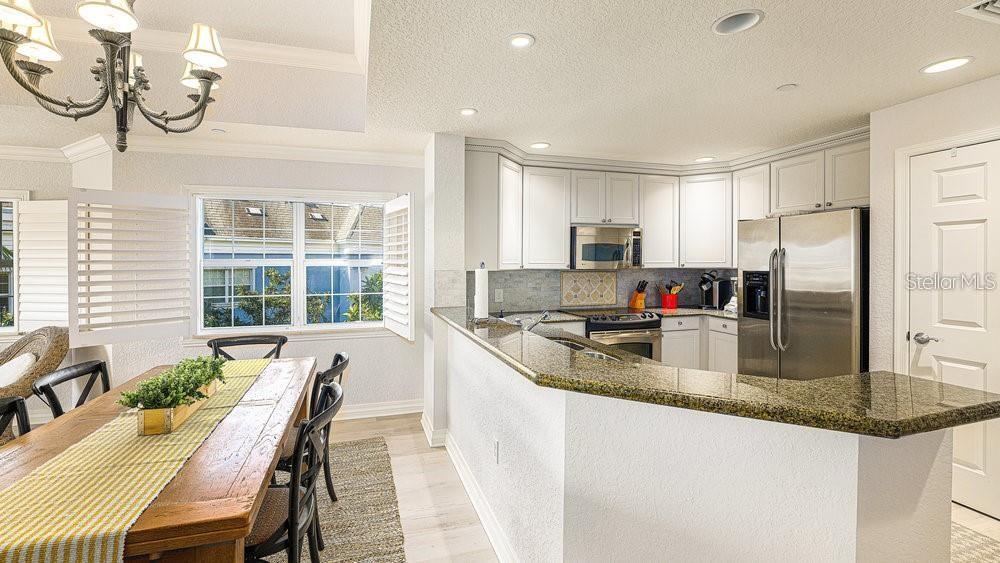 7650 Whisper Way, Unit 304 Reunion, FL 34747 - Photo 6 of 37 a kitchen with granite countertop a sink and stainless steel appliances