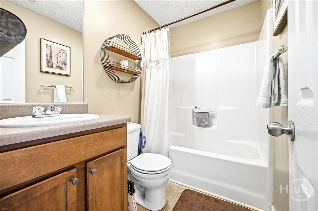 121 Crestview Drive Carnesville, GA 30521 - Photo 21 of 28 Full bathroom featuring a single vanity with wood-finish cabinetry, a white porcelain sink, and a combination shower-tub unit