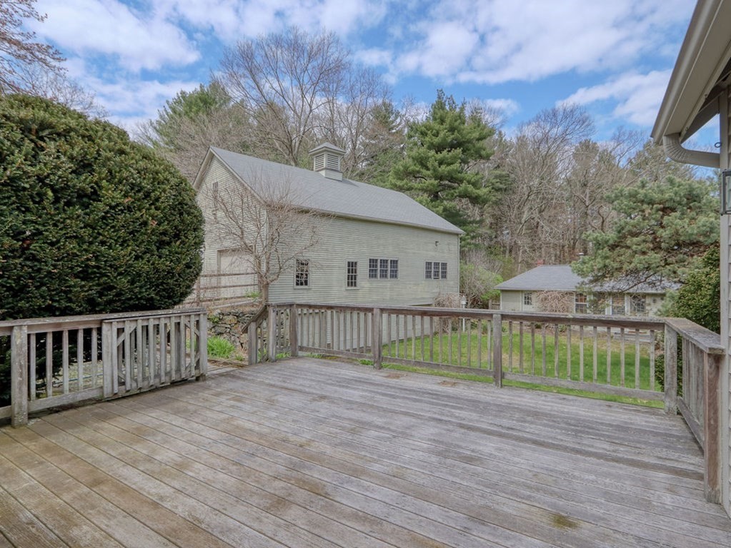 178 Dedham Street Dover, MA 02030 - Photo 5 of 42 a view of a house with a wooden deck and a yard