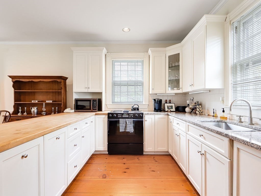 178 Dedham Street Dover, MA 02030 - Photo 7 of 42 a large white kitchen with granite countertop a stove top oven a sink dishwasher and white cabinets with wooden floor