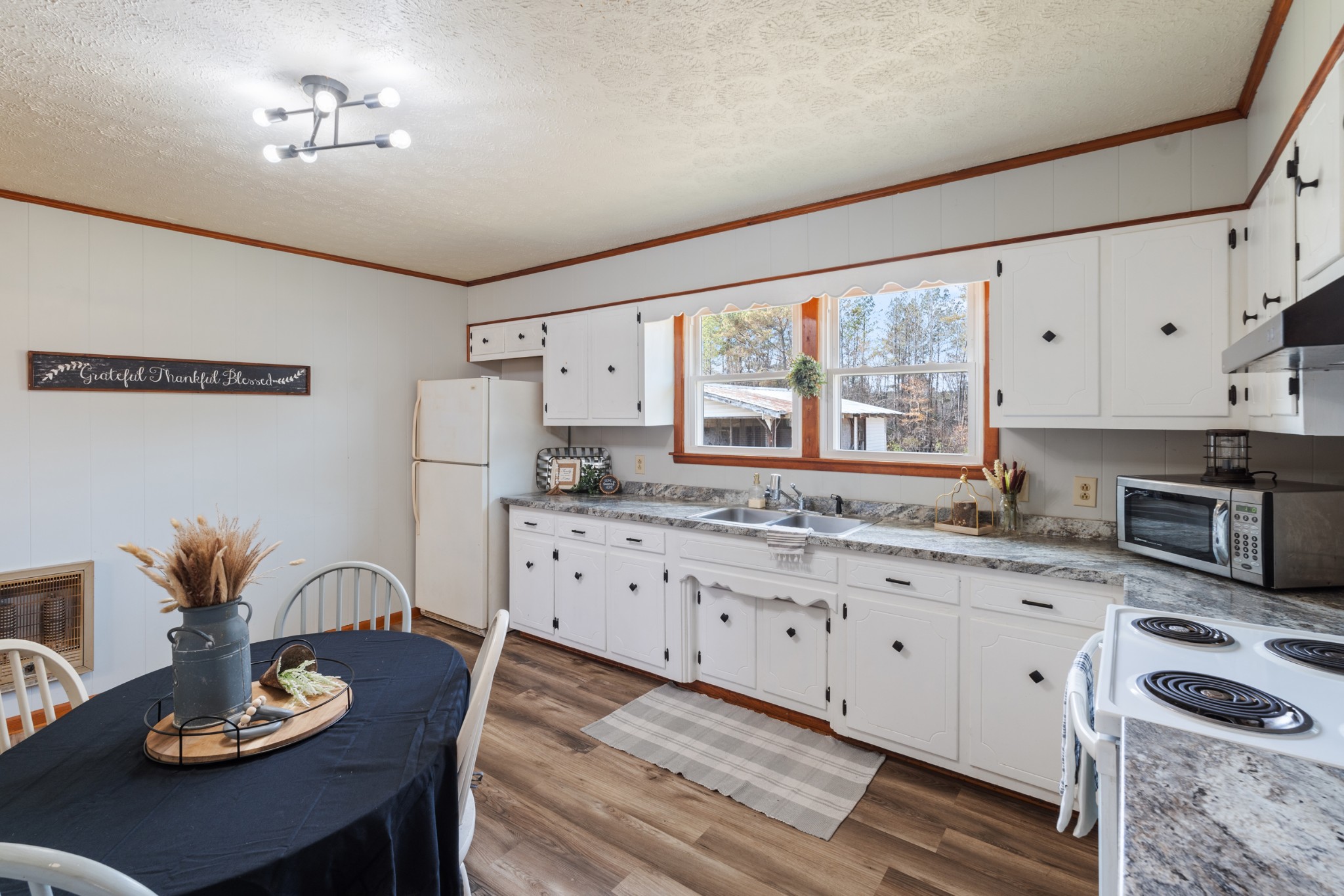 7139 Anderson Road Fairview, TN 37062 - Photo 6 of 26 a kitchen with granite countertop stainless steel appliances sink stove and white cabinets