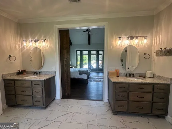 a kitchen with stainless steel appliances a sink a stove a refrigerator cabinets and a dining table