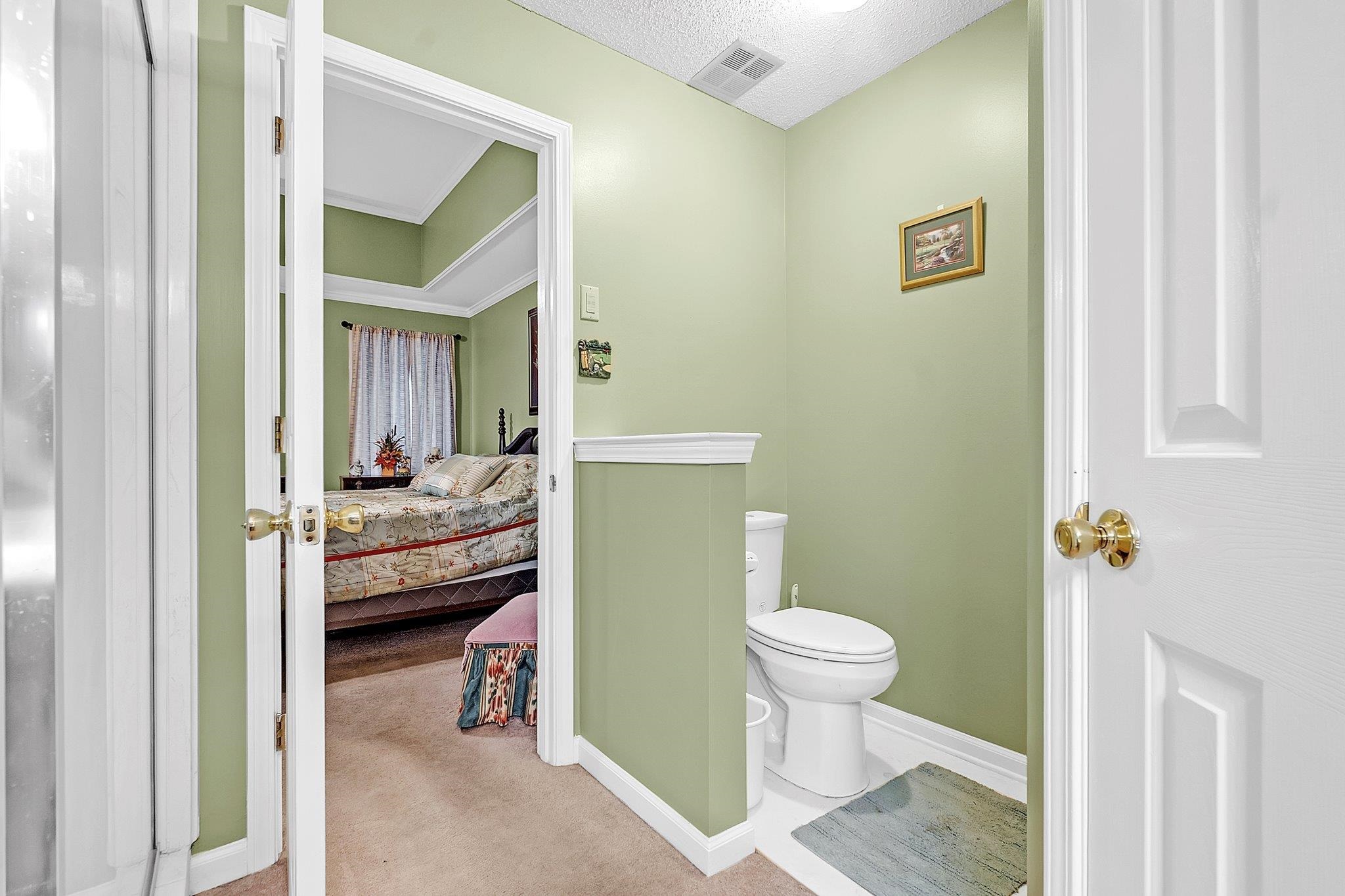 4020 Altruria Road Bartlett, TN 38135 - Photo 16 of 25 Two-panel interior door with brass hardware leading to a room featuring a tray ceiling with crown molding