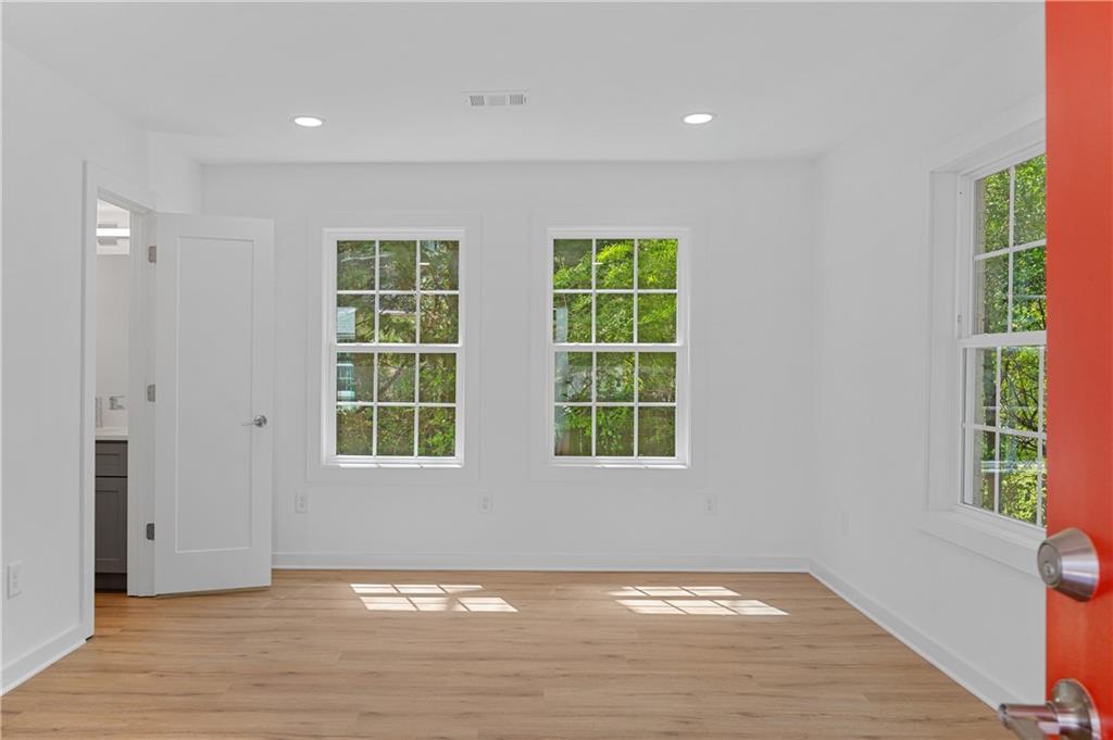 237 Howard Street Northeast, Unit 3 Atlanta, GA 30317 - Photo 2 of 18 a view of an empty room with wooden floor and a window