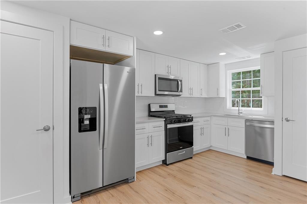 237 Howard Street Northeast, Unit 3 Atlanta, GA 30317 - Photo 6 of 18 a kitchen with a refrigerator stove and microwave