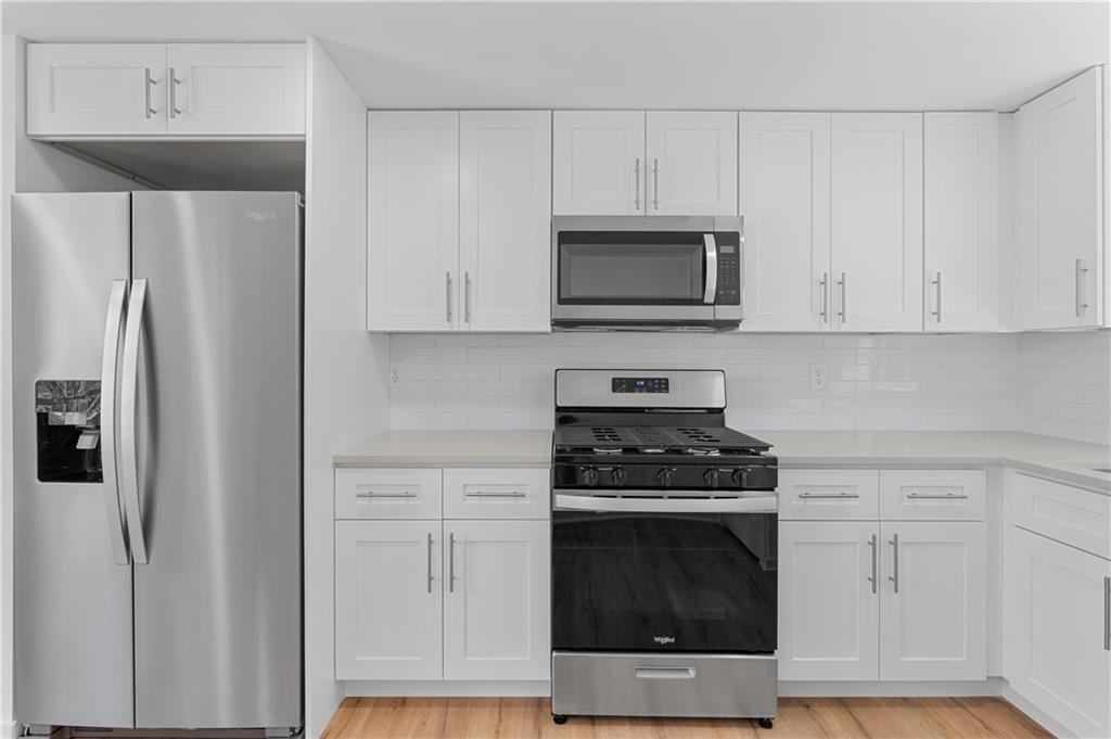 237 Howard Street Northeast, Unit 3 Atlanta, GA 30317 - Photo 8 of 18 a kitchen with white cabinets and stainless steel appliances