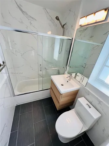 a bathroom with a sink mirror and toilet
