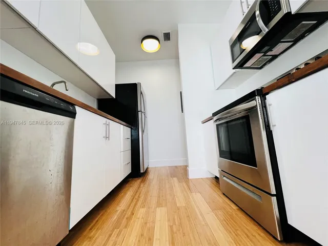 a view of hallway with wooden floor and stairs