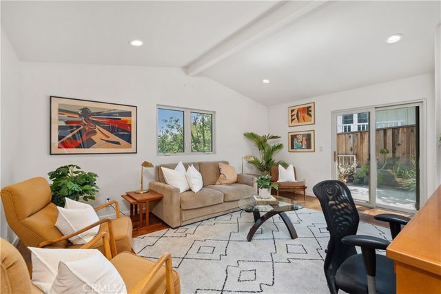a living room with furniture potted plant and large window