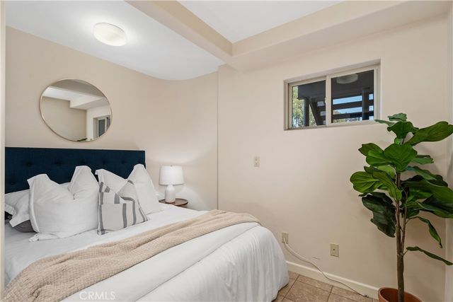 a bedroom with bed and a potted plant