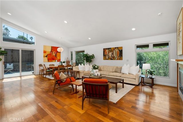 a living room with furniture a wooden floor and a large window