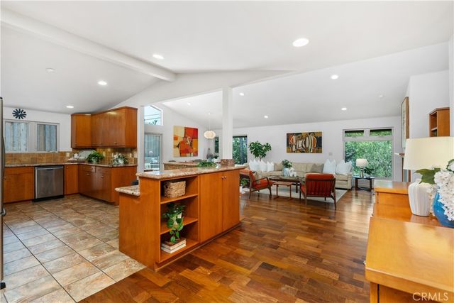 a kitchen with stainless steel appliances granite countertop a refrigerator a stove and a sink