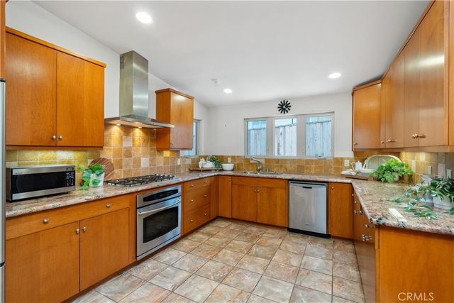 a large kitchen with granite countertop a stove a sink and a microwave