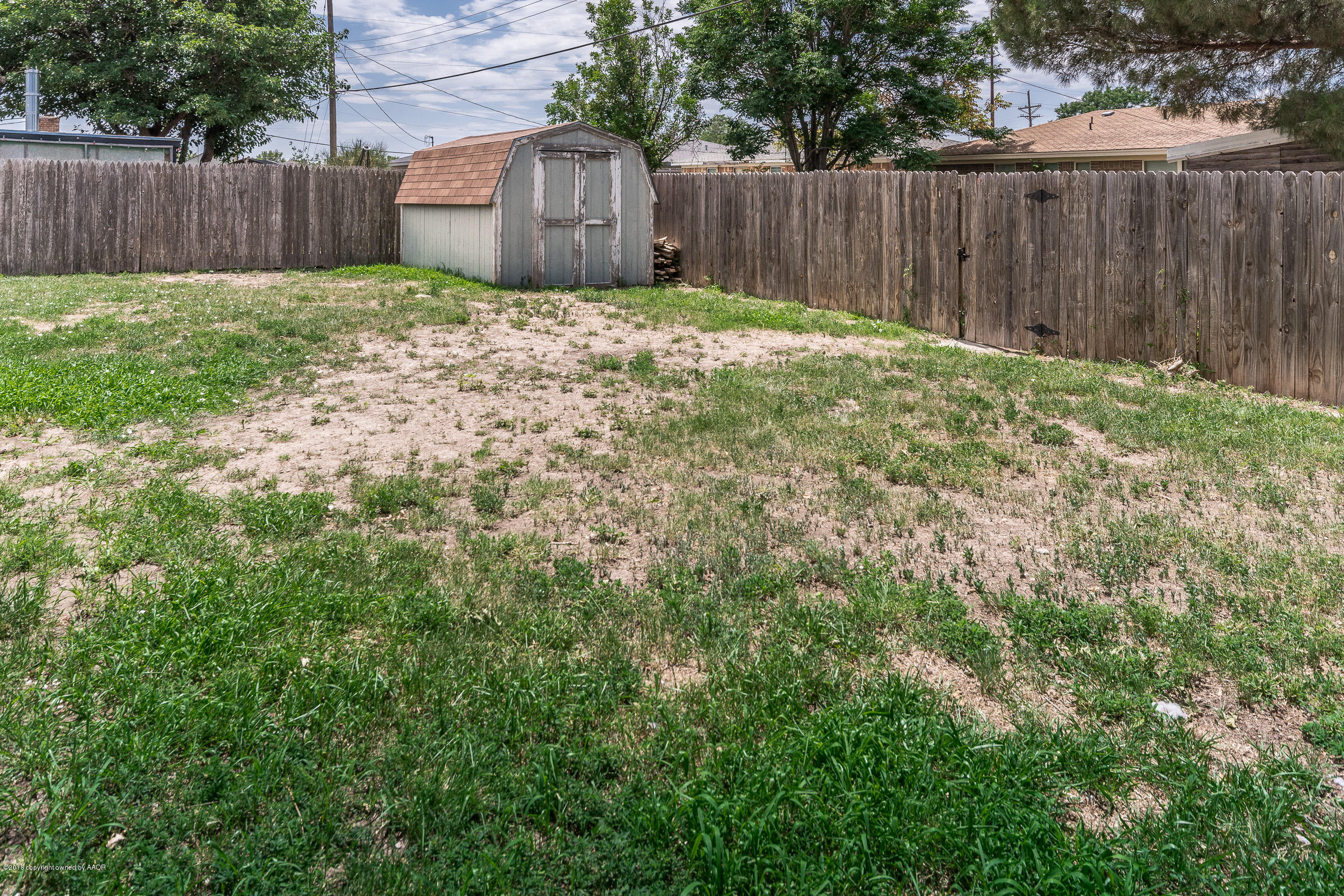 5340 Whitney Lane Amarillo, TX 79110 - Photo 13 of 14 a view of a backyard with large trees and wooden fence