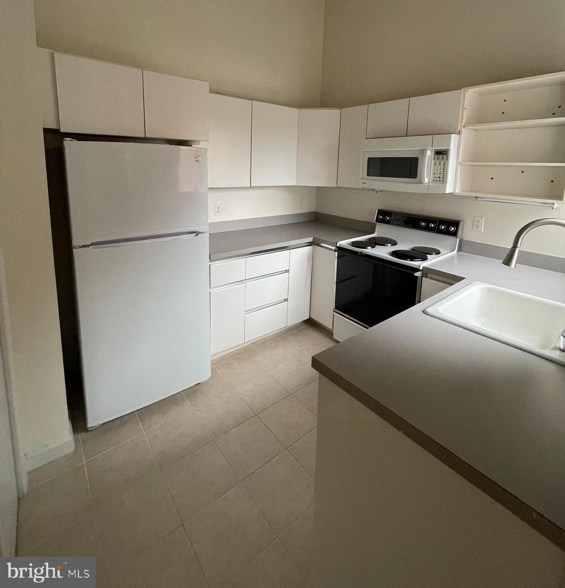 a kitchen with stainless steel appliances a refrigerator sink and microwave