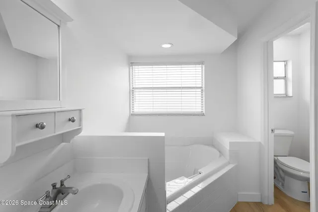 a bathroom with a tub a sink and a toilet