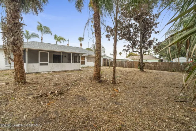 a view of a white house with a yard and sitting area