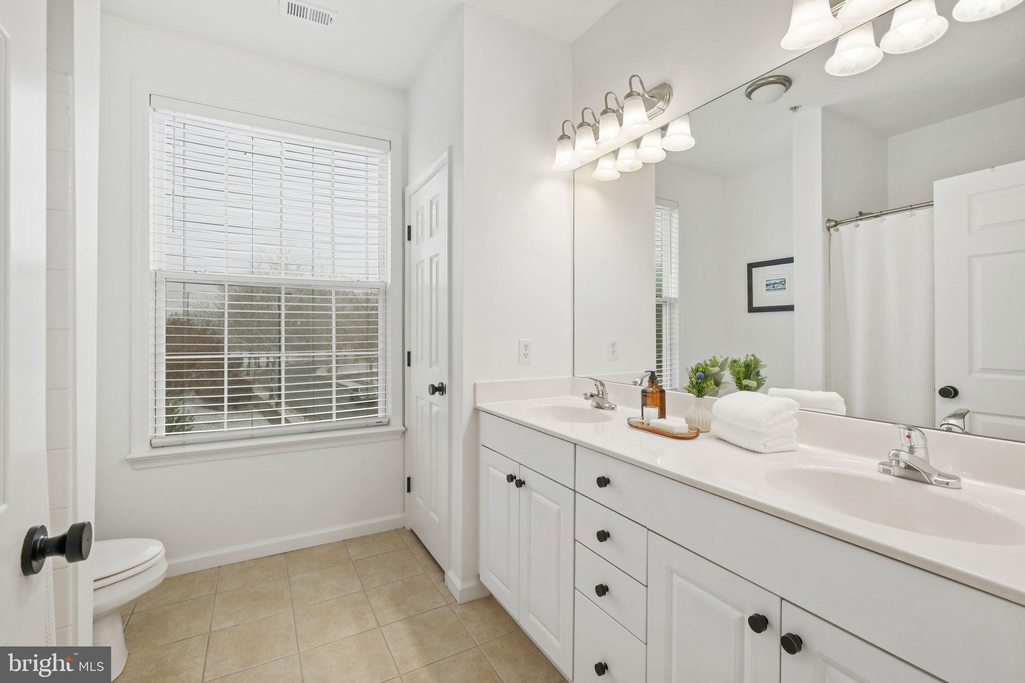 8 Granite Place, Unit 266 Gaithersburg, MD 20878 - Photo 23 of 49 a bathroom with a double vanity sink a mirror a and a window