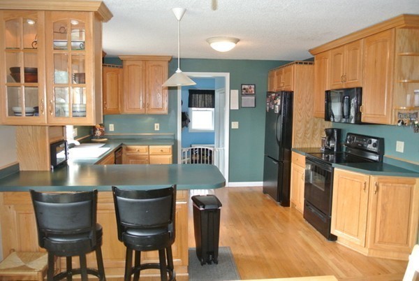 251 High St Extension Lancaster, MA 01523 - Photo 3 of 18 a kitchen with stainless steel appliances granite countertop a refrigerator a stove a sink dishwasher with a dining table and chairs