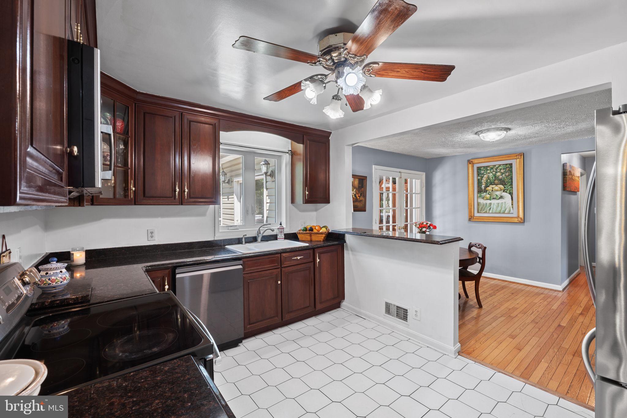 23439 Watson Road Leesburg, VA 20175 - Photo 12 of 41 a kitchen with stainless steel appliances granite countertop a sink dishwasher stove top oven and cabinets with wooden floor