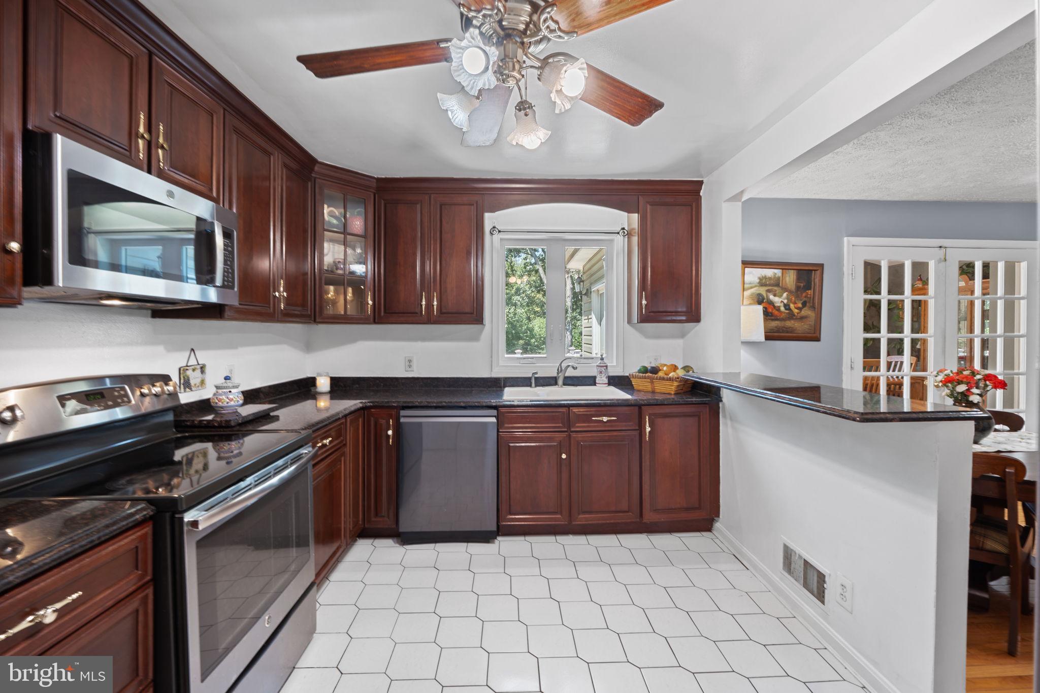 23439 Watson Road Leesburg, VA 20175 - Photo 13 of 41 a kitchen with stainless steel appliances granite countertop a stove top oven a sink dishwasher and a microwave oven on the blue kitchen countertops
