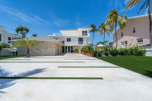 a front view of a house with a yard and potted plants