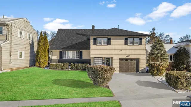 a front view of a house with a garden and yard