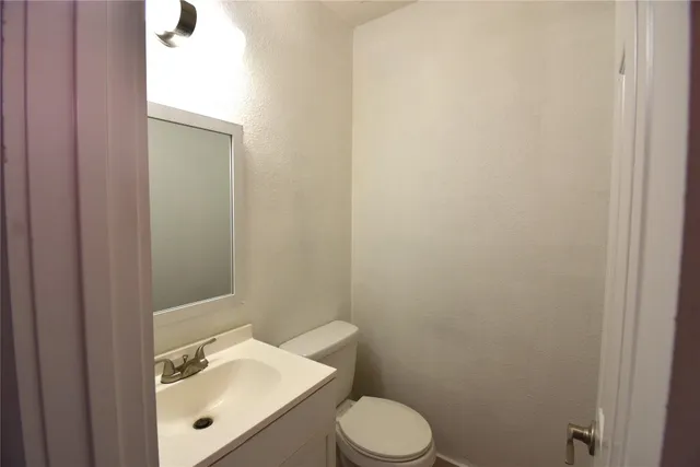 a bathroom with a sink a toilet and mirror