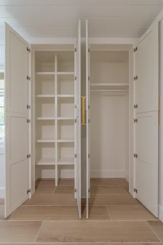 a view of an empty room with cabinet and door