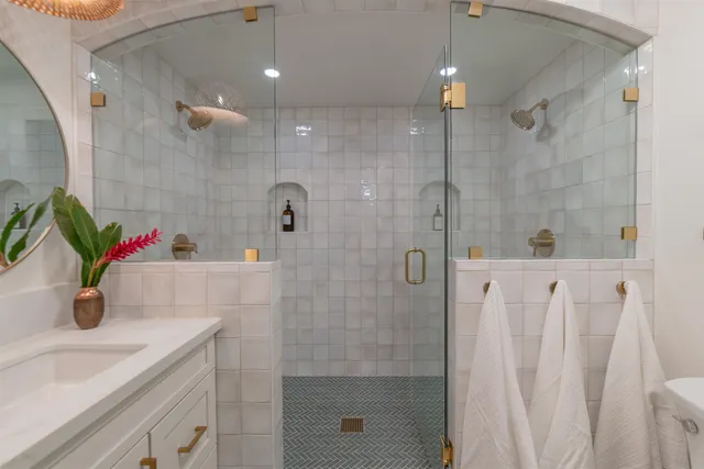 a bathroom with a shower sink and mirror