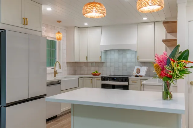 a kitchen with kitchen island a counter top space cabinets and stainless steel appliances