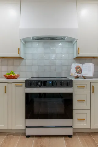 a stove top oven sitting inside of a kitchen