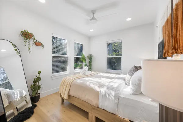 a bedroom with a large bed and a potted plant