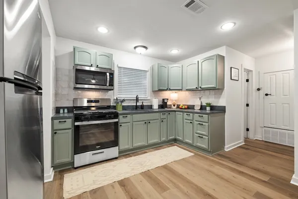 a bedroom with a bed a chair and a large window