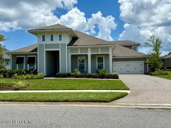 a front view of a house with a garden and plants