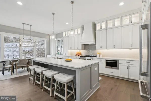 a kitchen with a stove and chairs