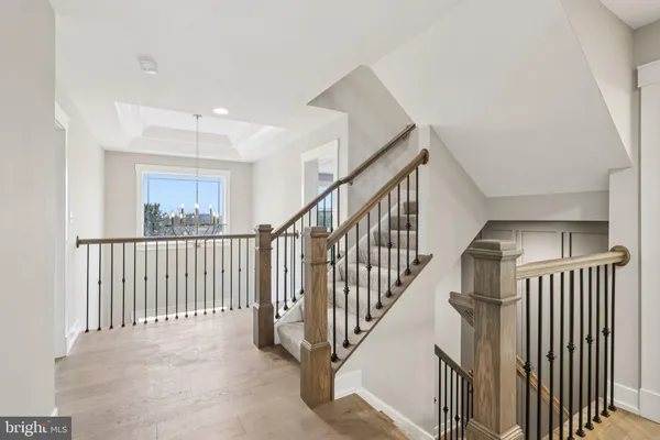 a view of staircase with lots of frames on wall and windows