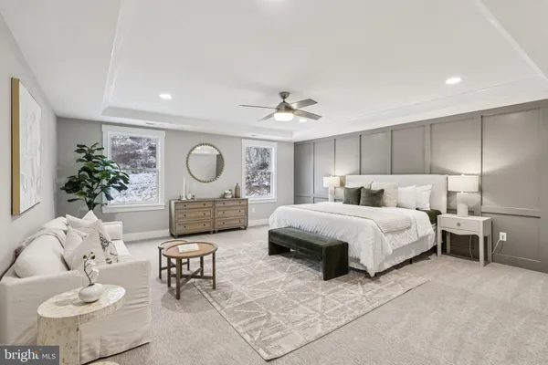 a spacious bedroom with a bed a couch and a potted plant