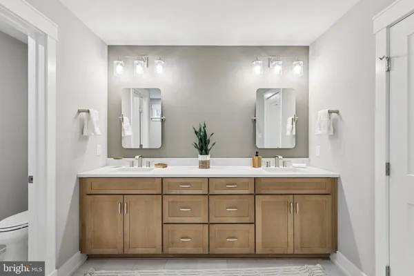 a bathroom with a double vanity sink mirror and toilet