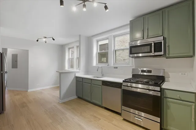 a kitchen with stainless steel appliances granite countertop a stove and a microwave