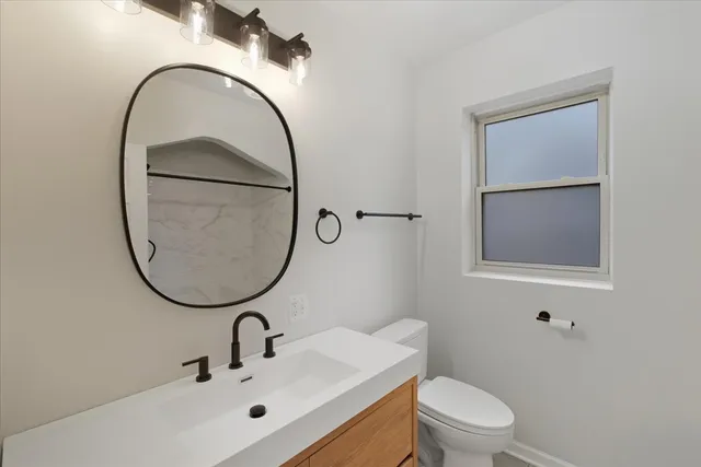 a bathroom with a sink a mirror and a toilet