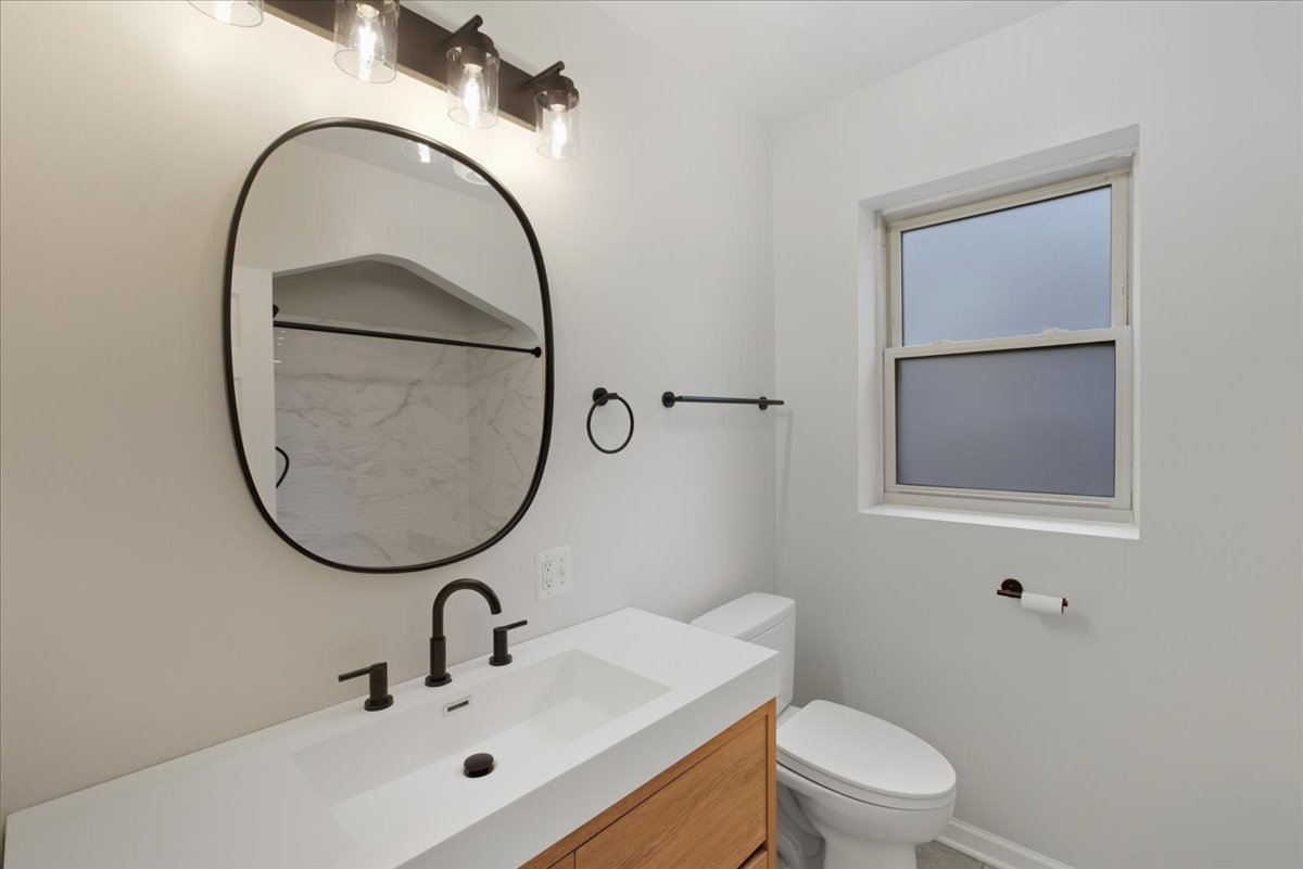 6136 North Mozart Street, Unit 4 Chicago, IL 60659 - Photo 9 of 10 a bathroom with a sink a mirror and a toilet