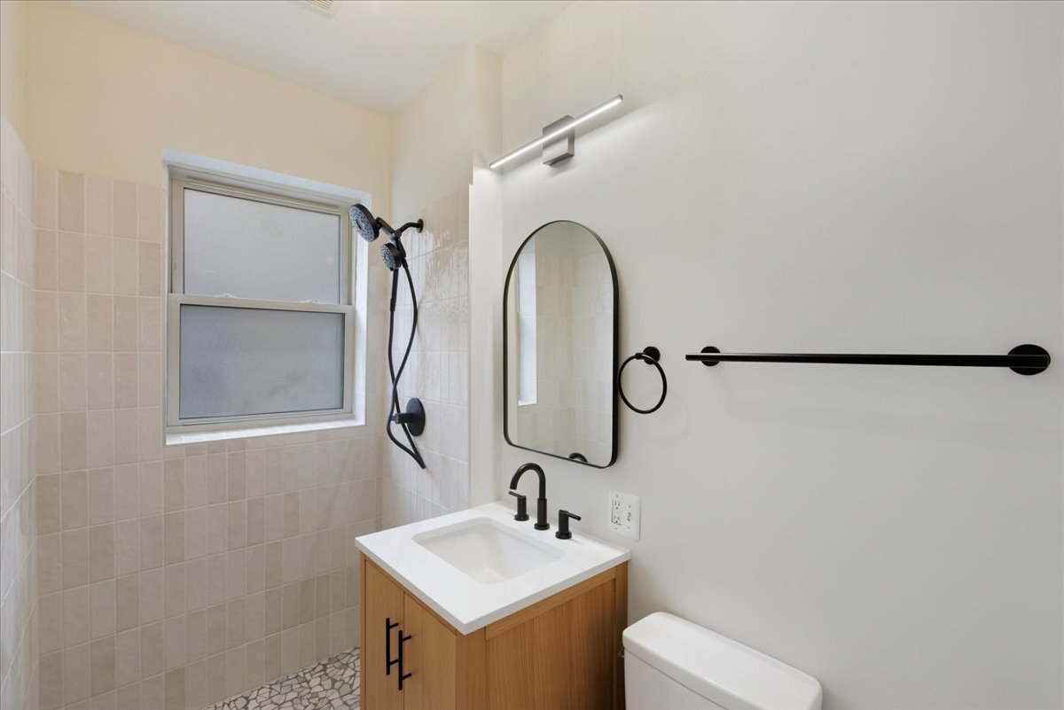 6136 North Mozart Street, Unit 4 Chicago, IL 60659 - Photo 10 of 10 a bathroom with a sink and mirror with toilet