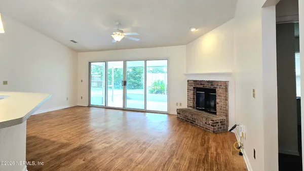 a view of empty room with wooden floor and fireplace