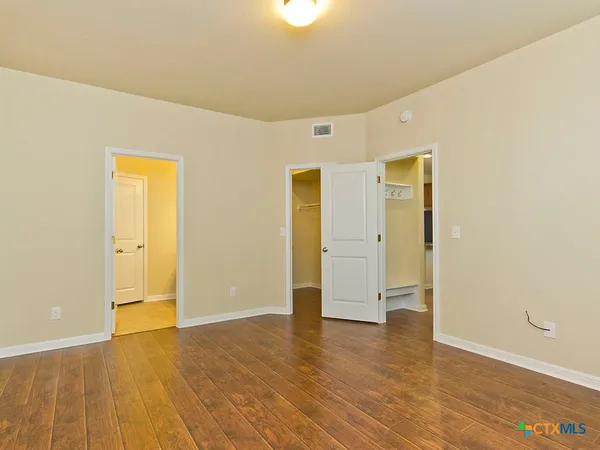 a view of an empty room with wooden floor