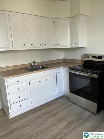a kitchen with granite countertop white cabinets and stainless steel appliances